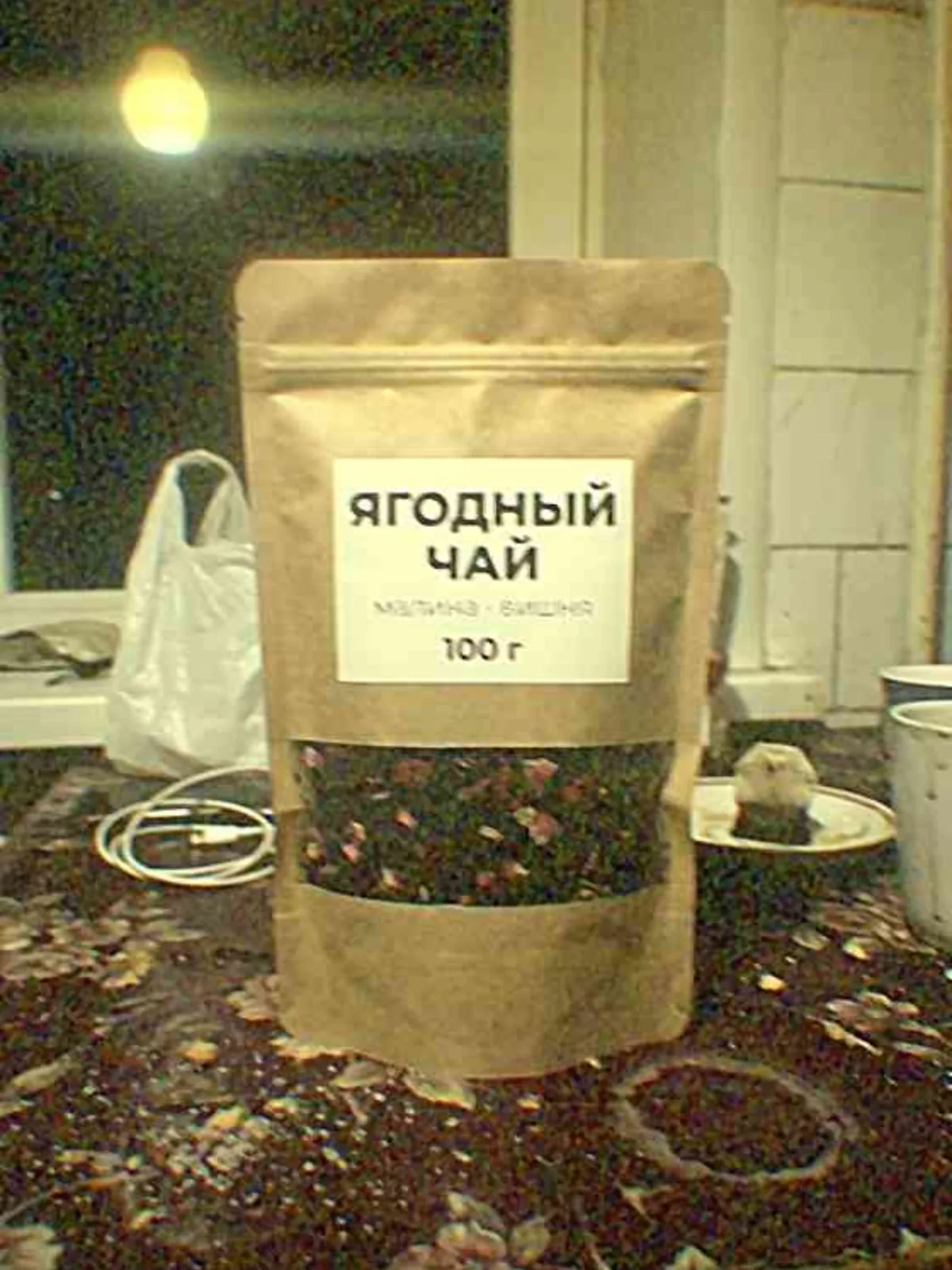 Пакет ягодного чая, снятый на телефон вечером на кухонном столе